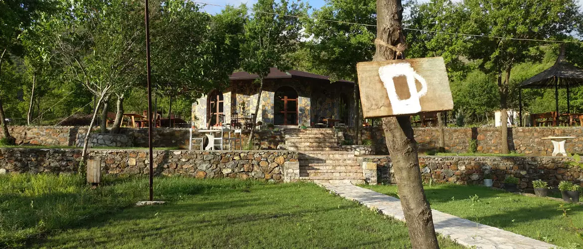 Agora camping, agora farmhouse camping, Campingplatz in Albanien, grüne Terassen und im HIntergrund ein großer PAvillion aus Stein